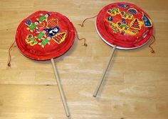 two red cake pops with decorations on them sitting on a wooden table next to each other