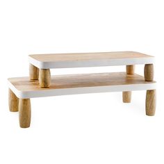 two wooden benches sitting next to each other on top of a white table with wood legs