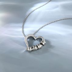 This sterling silver necklace's pendant, a hollow out heart clasp design, delicately crafted from pure silver. It's a beautiful symbol of love, friendship, and family. The hollow out heart clasp pendant allows you to customize the necklace by adding rings inscribed with the names of your loved ones. Each circle is a reminder of the special bond you share with each family member, a tangible expression of your love and appreciation. As you wear the heart necklace with your family name customized, Sterling Silver Heart Pendant Jewelry Gift, Sterling Silver Double Heart Engraved Charm Necklace, Silver Double Heart Engraved Necklaces, Heart-shaped Sterling Silver Jewelry With Silver Clasp, Silver Sterling Silver Heart Necklace, Sterling Silver White Gold Necklace With Heart Beads, White Gold Heart-shaped Jewelry With Sterling Silver Clasp, White Gold Sterling Silver Necklace With Heart Beads, Silver Round Necklace With Heart Beads