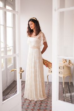 a woman in a white dress is standing by the door