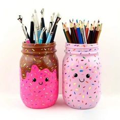 two jars filled with pens and pencils sitting next to each other