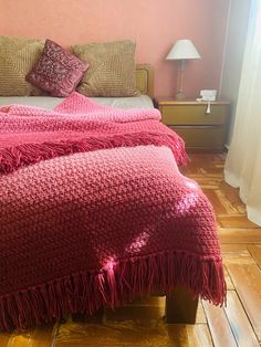 a bed with a pink blanket on top of it