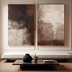 two paintings hang on the wall above a coffee table