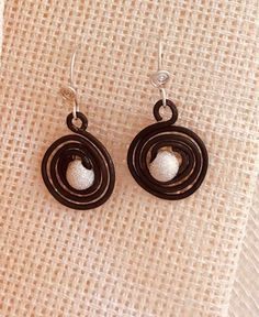 simple, graphic, matte black steel spirals hold a sparkling silver bead for a modern hip look... very light weight with 26 gauge, sterling silver, hand twisted, unique french style ear wire, extra rubber ear wire backs included long , small version hangs about 1-3/4" from top of ear wire to bottom of dangle shorter but large version hangs about 1" long, 5/8" wide perfect gift for the sky watcher, or your favorite sci-fi fan matching pendant and necklaces listed separately I like wearing these with the Solar Eclipse Pendants or the Sand Dollar Deluxe Pendant Slight variations occur due to the nature of handmade items HandMade in Portland, Oregon by Catherine Stemper, Beggar's Tomb Silver Gift shopping? I offer complimentary gift wrap :) all orders are gift wrapped all pretty for you, no cha Black Spiral Earrings For Gift, Black Spiral Earrings As Gift, Nickel-free Black Spiral Jewelry, Spiral Earrings, Silver Gifts, Black Steel, Silver Beads, Silver Earrings, Jewelry Earrings Dangle