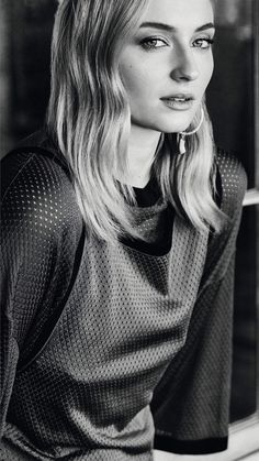 black and white photograph of a woman leaning on a window sill looking at the camera