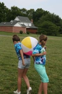 two girls are playing with a large beach ball