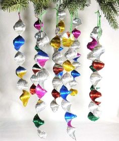 christmas ornaments hanging from a tree on a white background with pine branches in the foreground