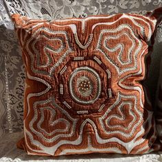 an orange and white pillow sitting on top of a couch