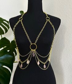 Get ready to add some glamour to your wardrobe with the Crystal Body Chain 18k Gold Plated Brass Top Piece. This body chain is perfect for anyone looking to add some festival vibes to their outfit. The top piece only body chain features wire wrapped amethyst and rose quartz crystals that are sure to catch everyone's attention. Crafted with 18k gold plated brass, this body chain is durable and long-lasting, ensuring that it won't break or tarnish easily. The high-quality materials used in making Torso Chain Jewelry, Bohemian Adjustable Waist Chain For Festivals, Adjustable Bohemian Waist Chain For Festivals, Trendy Chain Body Jewelry For Festival, Trendy Festival Body Jewelry With Chain, Bohemian Gold Body Jewelry For The Beach, Bohemian Body Jewelry With Chain For Festivals, Bohemian Festival Body Jewelry With Chain, Bohemian Chain Body Jewelry For Festivals