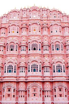 a pink building with many windows and balconies on the top floor in india