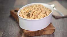 a white bowl filled with cereal on top of a wooden board