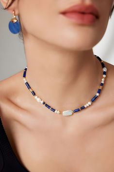 This captivating necklace is a blend of bohemian flair and classic elegance, featuring the deep, celestial blue of lapis lazuli interspersed with creamy freshwater pearls. The vibrant lapis beads, known for their connection to wisdom and truth, provide a striking contrast to the pearls' soft luminescence, creating an enchanting visual harmony. Accents of gold add a touch of opulence to the piece, catching the light and lending a luxurious finish to the boho-chic aesthetic. Artfully arranged, the necklace is an embodiment of artisanal craft, perfect for those who adore unique and meaningful jewelry. This necklace isn't just an accessory; it's a conversation starter and a statement of style that's versatile enough for daywear and striking enough for evening engagements. Whether it's a though Blue Single Strand Bohemian Jewelry, Bohemian Pearl Necklace With Spacer Beads, Handmade Blue Pearl Necklace For Gift, Blue Pearl Necklace With Natural Stones As A Gift, Handmade Lapis Lazuli Necklaces, Bohemian Blue Single Strand Jewelry, Blue Bohemian Pearl Necklace For Gift, Blue Bohemian Pearl Necklace With Gemstone Beads, Blue Single Strand Pearl Necklace As Gift