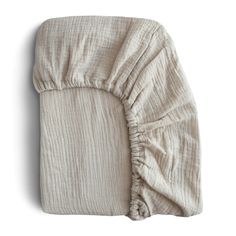 an unmade bed with a ruffled cover on it's back and side