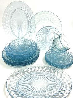 several glass plates and bowls on a white surface