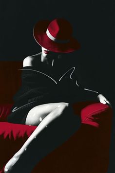 a woman sitting on top of a red couch wearing a red hat and black dress