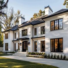 a large white house with lots of windows on the front and side of it's facade