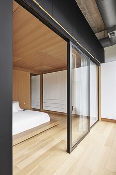 a bedroom with wooden floors and sliding glass doors