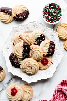 a plate full of cookies with sprinkles and candy on the table next to it