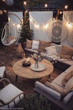 an outdoor living area with wicker furniture and string lights