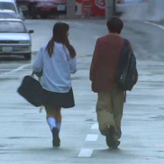 two people walking down the street with luggage