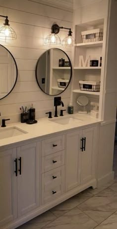 a bathroom with double sinks and two mirrors on the wall next to eachother