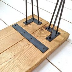 three metal poles are placed on top of a wooden floor with white tiles in the background