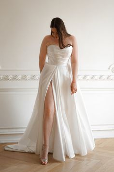 a woman in a white dress is standing on the floor with her legs spread out