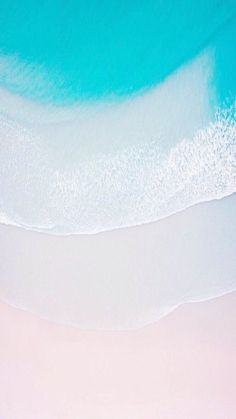 an aerial view of the beach and ocean with white sand, blue water and turquoise sky