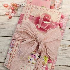 an open book with a pink rose on it and some other items around it,