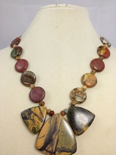 Each Round stone has a different design it is like having 14 different pictures. I like working with Red  Creek Jasper, so many colors Gray, yellow, red, and green. The Focal is  1 1/2" x1 1/2" in the middle The two on the side 1" x 1". Earrings are 2" long and toggle clasp in back, color is gunmetal. Multicolor Jasper Jewelry For Gift, Earthy Style Multicolor Round Jewelry, Multicolor Jasper Necklace For Gift, Earthy Multicolor Round Jewelry, Unique Multicolor Jasper Jewelry, Handmade Multicolor Jasper Jewelry, Multicolor Jasper Gemstone Beads Jewelry, Adjustable Multicolor Jasper Necklaces, Unique Multicolor Jasper Necklaces