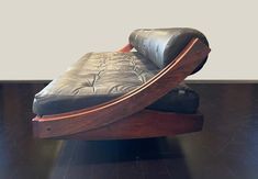 a chair that is sitting on top of a hard wood floor with black leather upholster