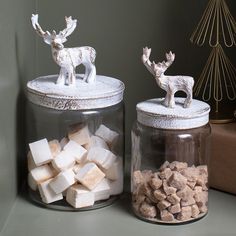 two glass jars filled with marshmallows and reindeer figurines