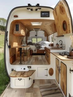 the interior of an rv with wood flooring and white walls, including wooden cabinets