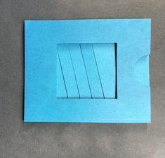 a piece of blue paper cut into four sections with strips sticking out of the middle