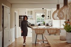 a woman standing in the middle of a kitchen