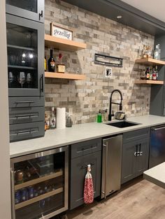 a kitchen with gray cabinets and stainless steel appliances