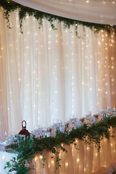 the table is set up with candles and greenery