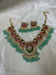 Indian Ethnic Jadau Ahemdabadi Kundan 22 Carat Gold Plated Sea Green Necklace Set * This Set Is made up with High Quality Pachi Kundan * 22 Carat Gold Plating Is used * High Quality Beads Are used * Set includes Necklace,Earrings  * Droppings color can be changed according to your requirement We made Jewelry in pachi kundan /Ahemdabadi kundan and made designs on order only , need atleast 25 days to make ,to do customization as they are acceptable. jewellery details :All jewellery are made with silver base and luxury gold plated next to real,generally we work on direct made on order.   We are  the dealers of Authentic and traditional Indian Jewelry  We  are honored to present you our elegant, stylish and unique designs with a  wide range of items in different Indian Jewelry category. Here i Kundan Chandbali Necklaces For Celebrations, Chandbali Kundan Necklaces For Celebrations, Celebration Kundan Chandbali Necklace, Eid Round Kundan Temple Necklace, Handmade Kundan Necklace For Ceremonial Occasions, Ceremonial Kundan Necklace Hand Set, Handmade Chandbali Kundan Bridal Necklace, Ceremonial Hand Set Kundan Necklace, Pink Tilla Necklace For Diwali