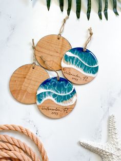 three wooden ornaments with blue and white waves on them