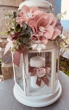 a white lantern with pink flowers on it