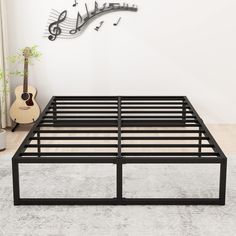 a metal bed frame with musical notes on the wall above it and an acoustic guitar