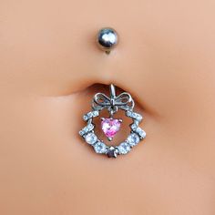 Product DetailsClear Pink CZ Gem Heart Wreath of Love Belly Ring Deck your body with a wreath of love - like this 14 gauge navel ring. It's made with a 3/8 inch 316L surgical grade stainless steel curved barbell with a 5mm top ball end. The bottom end features a festive wreath charm with a bow embellishment at the top and clear cubic zirconia gems all along the bottom. The wreath is further embellished by a dangling pink cubic zirconia gem heart. No matter what the season, why hang a wreath on y Heart-shaped Pink Belly Rings For Gift, Pink Heart-shaped Belly Rings For Gift, Cubic Zirconia Belly Rings For Gift, Cubic Zirconia Belly Rings As Gifts, Heart-shaped Silver Body Jewelry For Wedding, Gift Cubic Zirconia Belly Rings Internally Threaded, Silver Heart Belly Rings For Valentine's Day, Dainty Internally Threaded Belly Rings As Gift, Silver Belly Rings For Valentine's Day