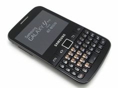 a black cell phone sitting on top of a white table next to a calculator