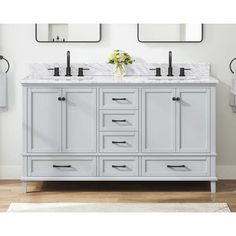 a bathroom vanity with two sinks and mirrors