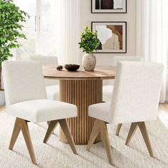 a dining room table with white chairs around it