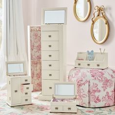 an assortment of jewelry boxes and mirrors in a room with pink flowers on the floor