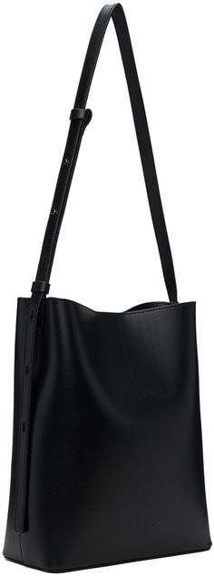 Buffed calfskin shoulder bag in black. · Adjustable crossbody strap · Logo embossed at face · Magnetic closure · Patch pocket at interior · Grained faux-leather lining · H11 x W9 x D4 Supplier color: Black Modern Business Crossbody Bucket Bag, Business Crossbody Bucket Bag With Detachable Handle, Modern Black Bucket Bag For Business, Sleek Leather Shoulder Bag With Adjustable Strap, Black Double Handle Bucket Bag For Business, Modern Black Textured Leather Shoulder Bag, Modern Black Business Bucket Bag, Black Textured Leather Top Handle Bucket Bag, Black Textured Leather Bucket Bag With Top Handle