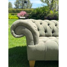 a couch sitting on top of a lush green field