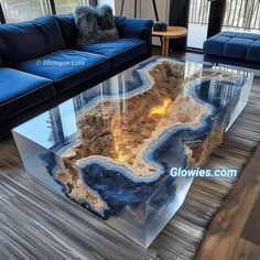 a living room with blue couches and a glass coffee table in the shape of an island