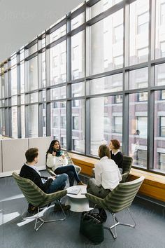 four people sitting in chairs and talking to each other